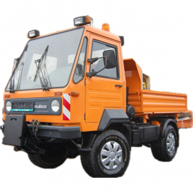 Multicar M26.5 in orange, fotografiert auf nassem Asphalt vor einer Werkhalle – kompakter Allrounder für Kommunaleinsätze. M26.5 - IVECO 2,8l Euro 3