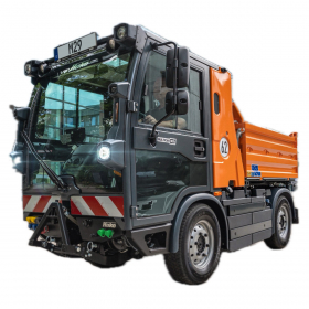 Ein orangefarbener Multicar M29 von Hako im Einsatzbereich der Kommunaltechnik steht vor einem modernen Glasgebäude Das kompakte M29